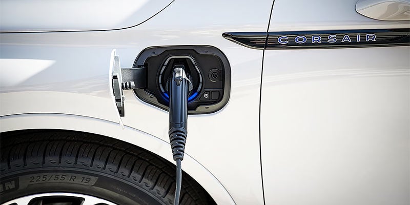 A close-up view of a 2024 white Lincoln Corsair charging at a station in Elizabethtown, KY, showcasing its modern design and electric capabilities.