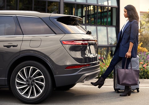 A woman with her hands full uses her foot to activate the available hands-free liftgate. | Don Franklin Lincoln Elizabethtown in Elizabethtown KY