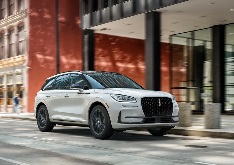 The 2024 Lincoln Corsair® SUV with the Jet Appearance Package and a Pristine White exterior is parked on a city street. | Don Franklin Lincoln Elizabethtown in Elizabethtown KY