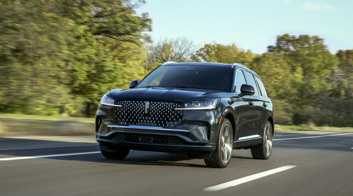 A 2025 Lincoln Black Label Aviator® SUV is being driven down a road lined with trees. | Don Franklin Lincoln Elizabethtown in Elizabethtown KY