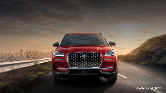 A 2025 red Lincoln Corsair® SUV is being driven down a road at sunset. | Don Franklin Lincoln Elizabethtown in Elizabethtown KY