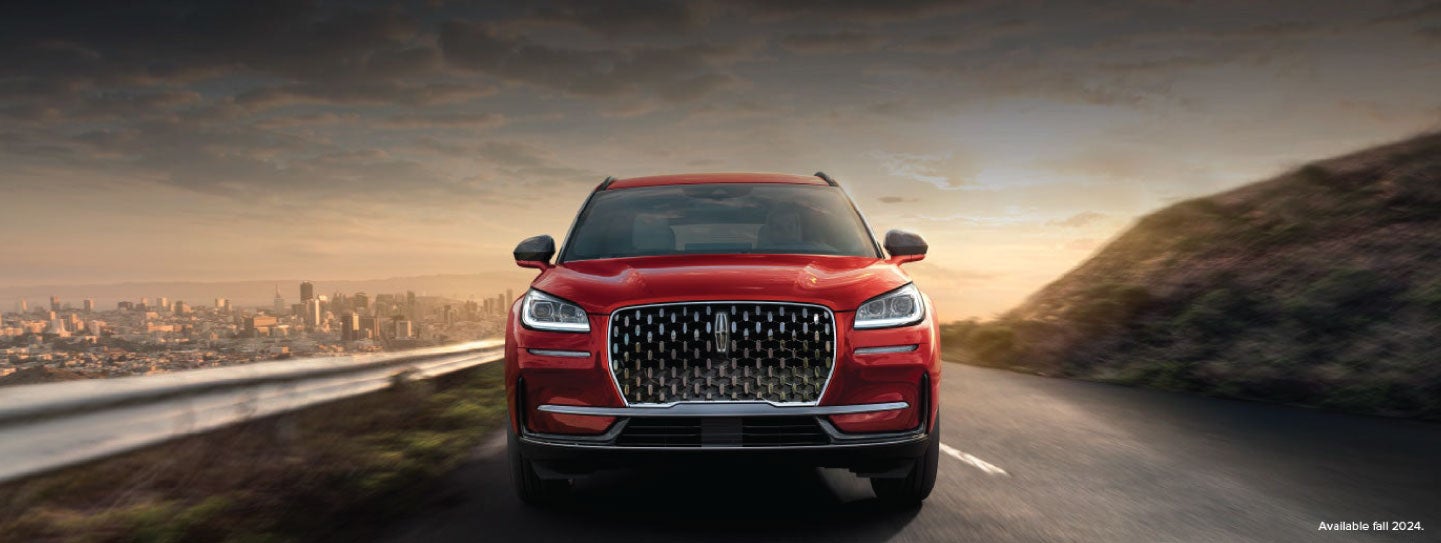 A 2025 red Lincoln Corsair® SUV is being driven down a road at sunset. | Don Franklin Lincoln Elizabethtown in Elizabethtown KY