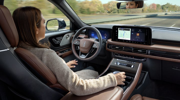 A 2026 Lincoln Aviator® SUV is being driven hands-free on a highway near a forest | Don Franklin Lincoln Elizabethtown in Elizabethtown KY